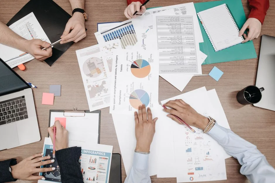 Une composition en flat lay mettant en scène des fournitures de bureau et un clipboard de stratégie de marque sur un espace de travail moderne.
